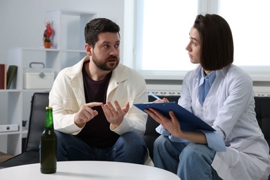 Alcoholic man having appointment with healthcare specialist in clinic. Addiction treatment