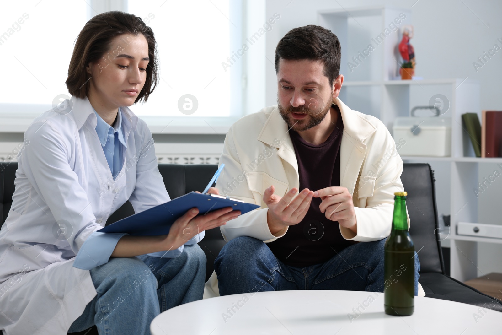 Photo of Alcoholic man having appointment with healthcare specialist in clinic. Addiction treatment