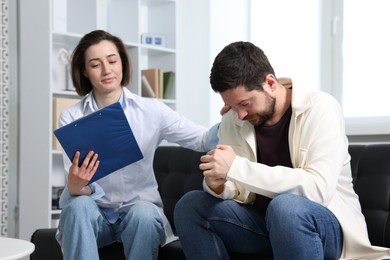 Photo of Alcoholic man having appointment with healthcare specialist in clinic. Addiction treatment