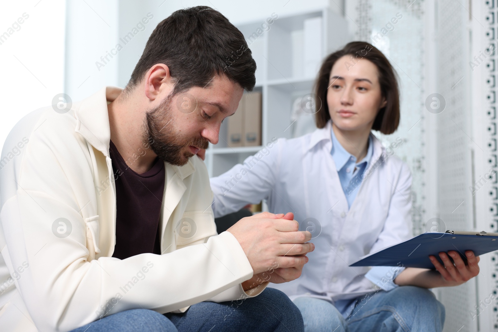 Photo of Alcoholic man having appointment with healthcare specialist in clinic. Addiction treatment