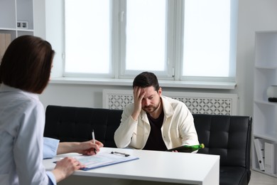 Photo of Alcoholic man having appointment with healthcare specialist in clinic. Addiction treatment