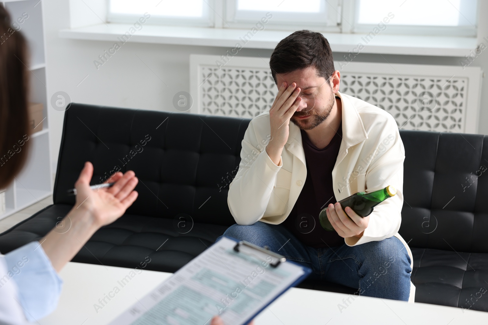 Photo of Alcoholic man having appointment with healthcare specialist in clinic. Addiction treatment