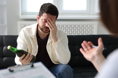 Photo of Alcoholic man having appointment with healthcare specialist in clinic. Addiction treatment