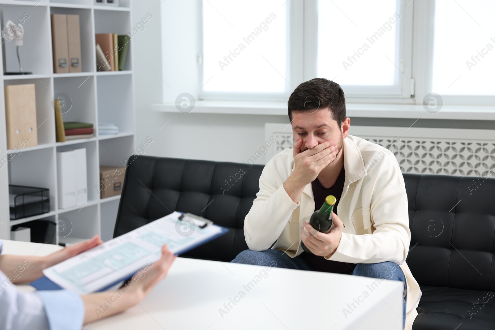 Photo of Alcoholic man having appointment with healthcare specialist in clinic. Addiction treatment