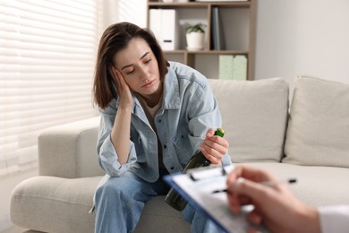 Photo of Alcoholic woman having appointment with healthcare specialist in clinic. Addiction treatment