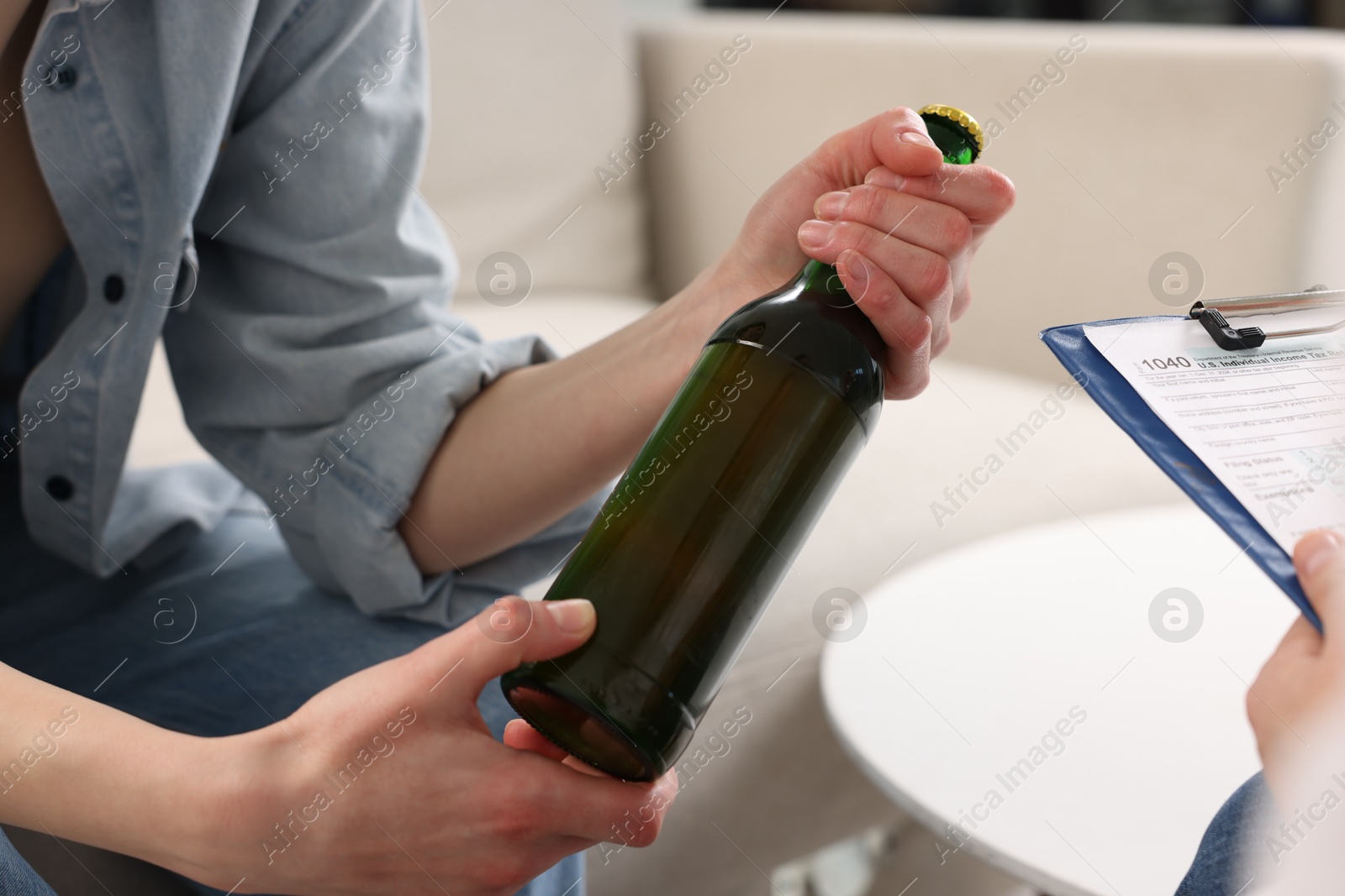 Photo of Healthcare specialist with bottle of beer in clinic, closeup. Addiction treatment