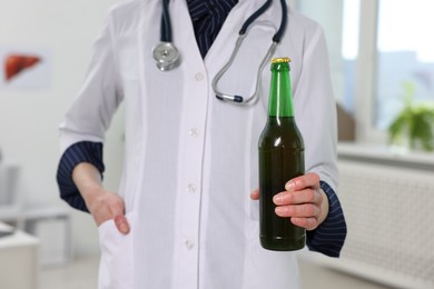 Photo of Healthcare specialist with bottle of beer in clinic, closeup. Addiction treatment