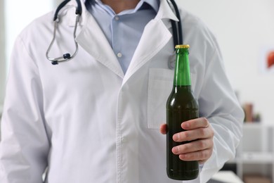 Photo of Healthcare specialist with bottle of beer in clinic, closeup. Addiction treatment