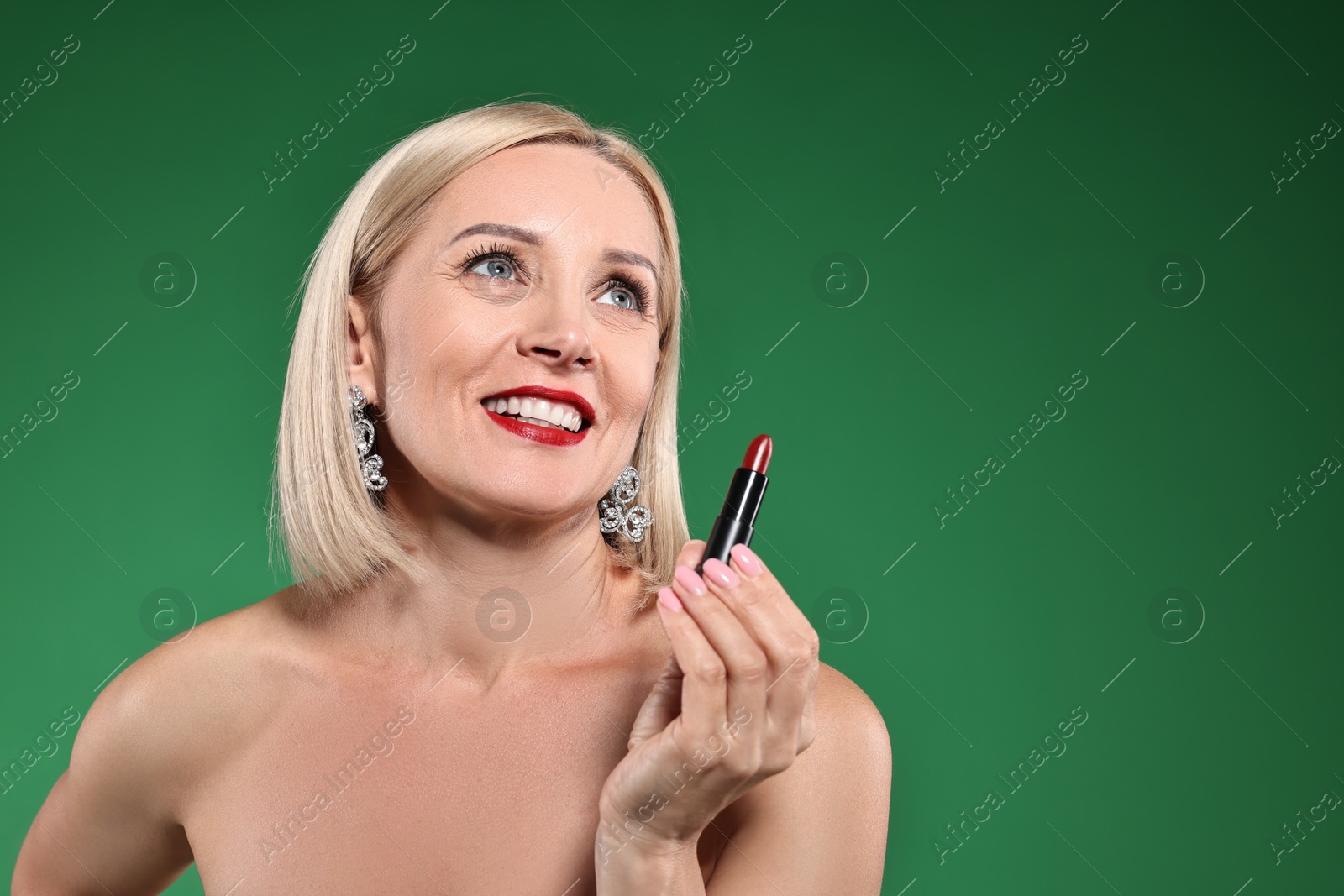 Photo of Smiling woman with red lipstick on green background. Space for text