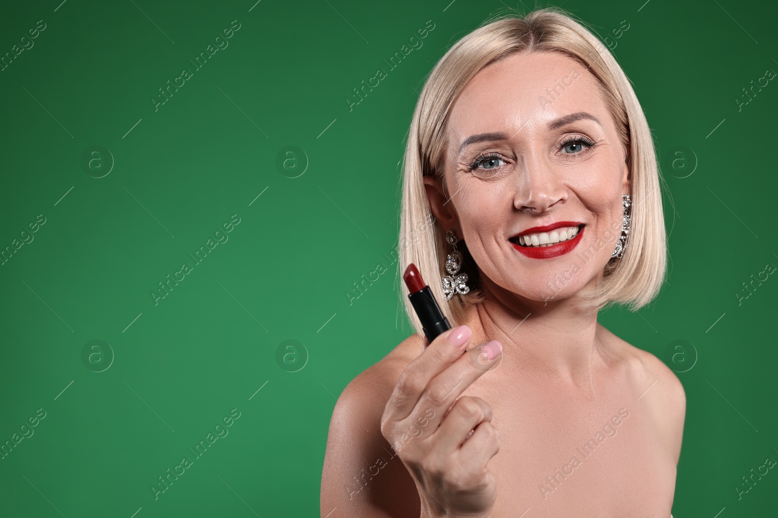 Photo of Smiling woman with red lipstick on green background. Space for text