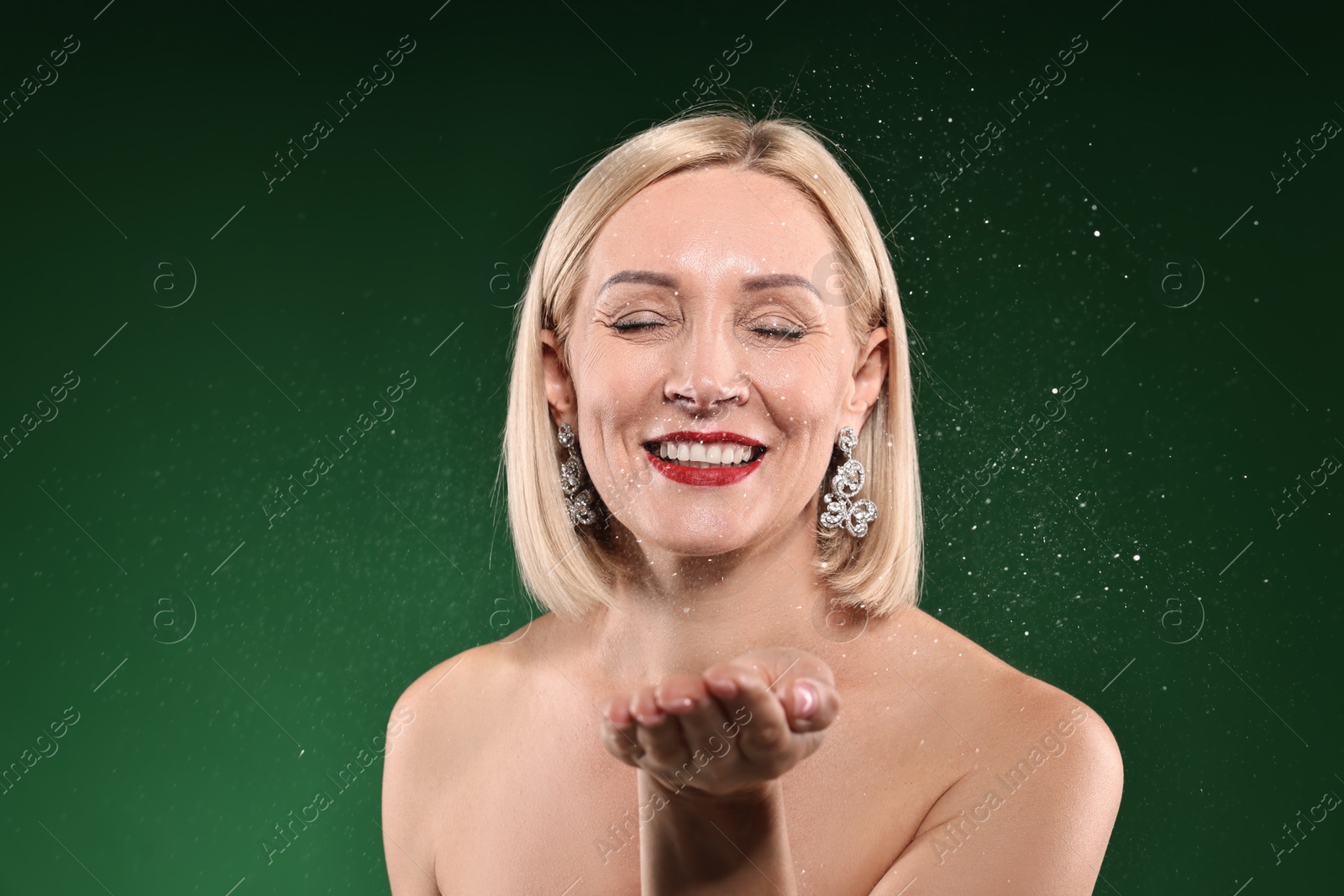 Photo of Happy woman with glitter on green background