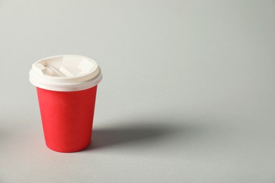 Photo of Paper cup with lid on grey background. Mockup for design