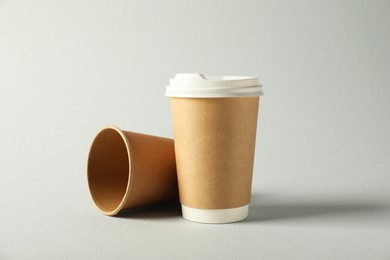 Photo of Paper cups with lids on grey background. Mockup for design