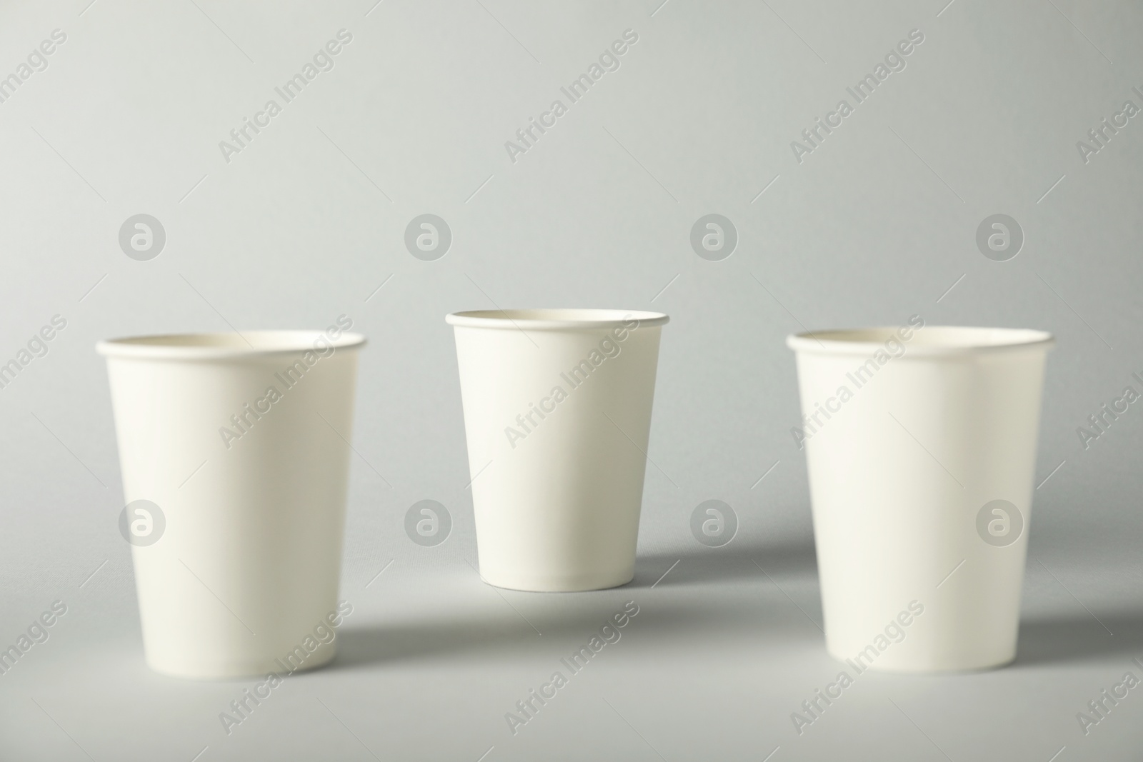 Paper cups on grey background. Mockup for design Photo of Paper cups on grey background. Mockup for design