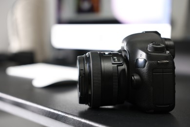 Photo of Professional camera on black desk indoors, closeup