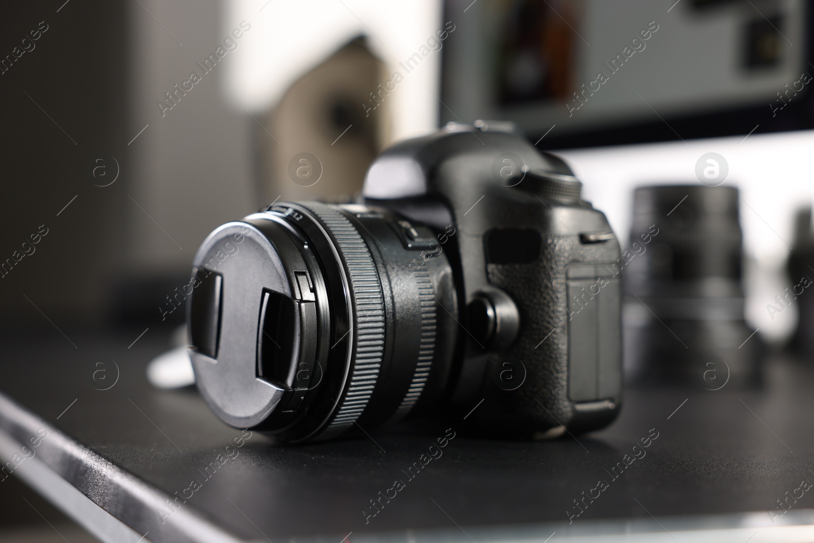 Photo of Professional camera on black desk indoors, closeup