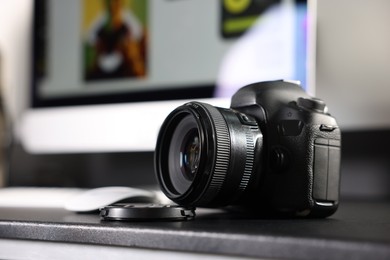 Photo of Professional camera on black desk indoors, closeup