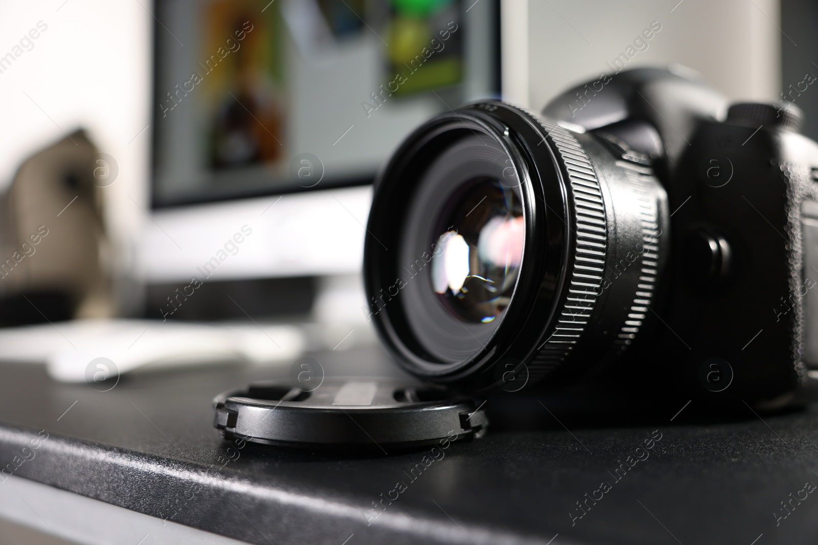 Photo of Professional camera on black desk indoors, closeup