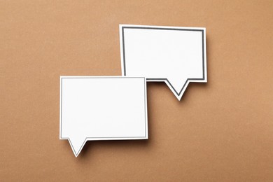 Photo of Blank speech bubbles on brown background, top view. Space for text