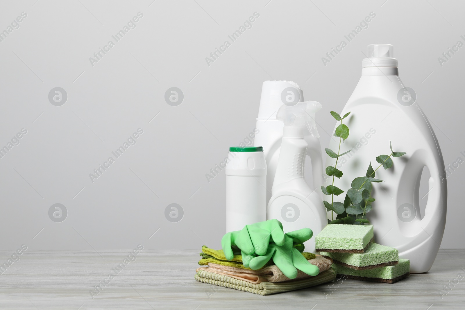 Photo of Eco-friendly cleaning products, supplies and eucalyptus branches on wooden table, space for text