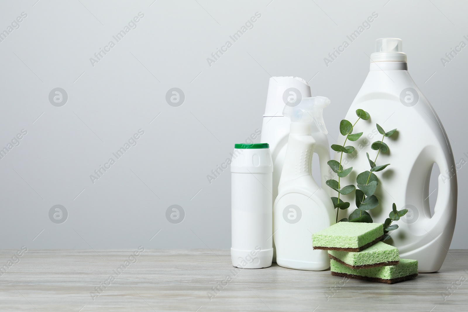 Photo of Eco-friendly cleaning products, supplies and eucalyptus branches on wooden table, space for text