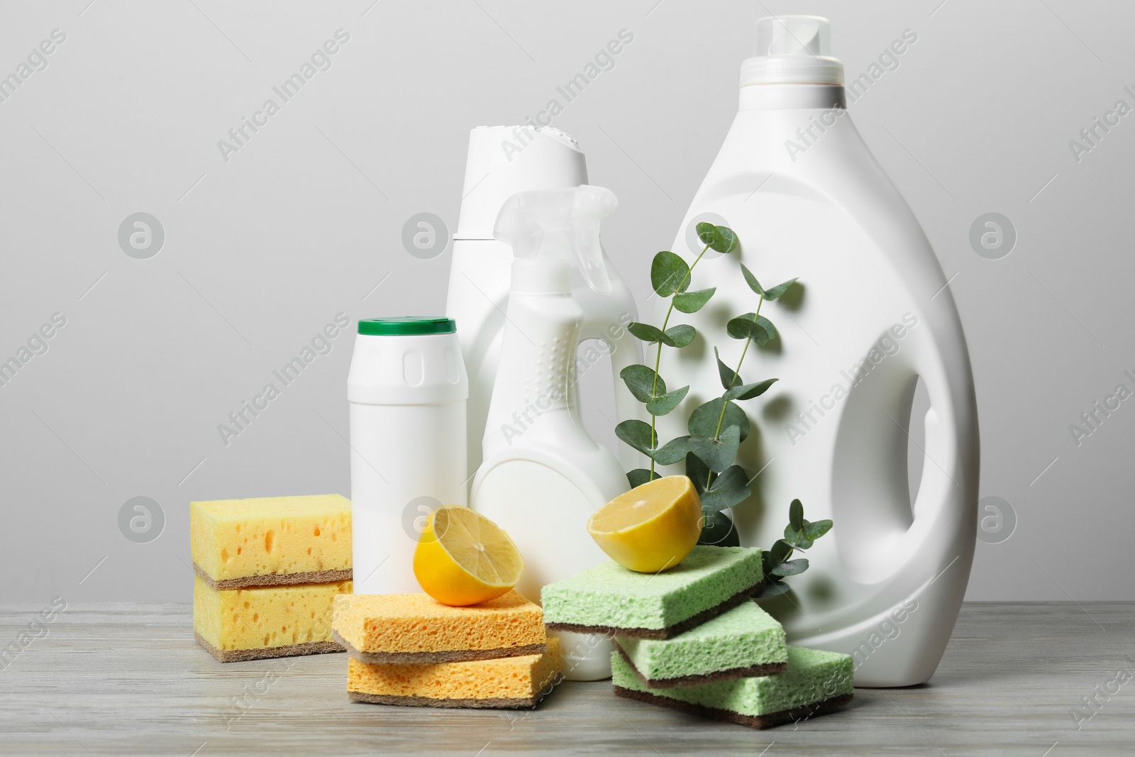 Photo of Eco-friendly cleaning products, supplies and eucalyptus branches on wooden table