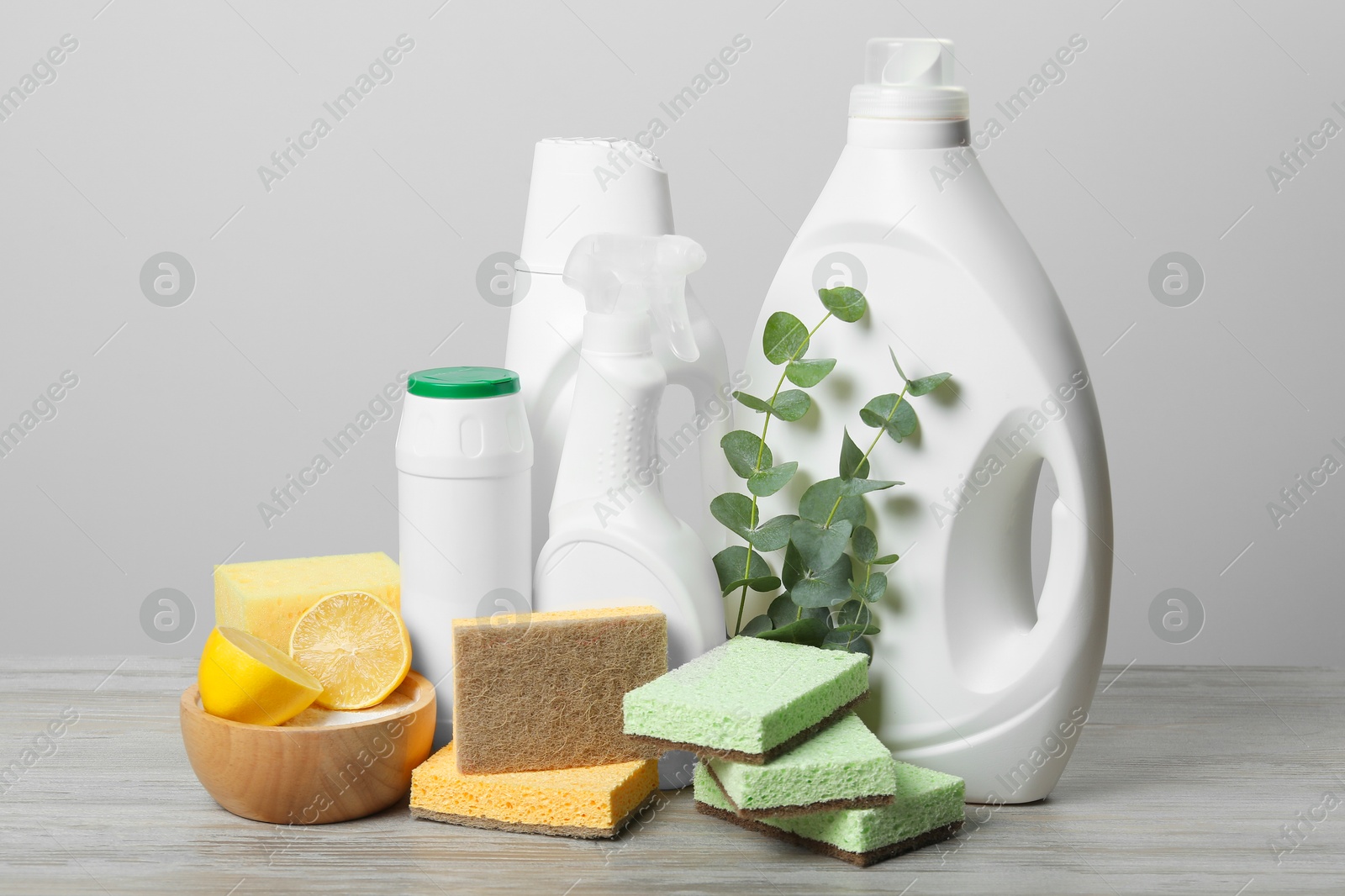 Photo of Eco-friendly cleaning products, supplies and eucalyptus branches on wooden table