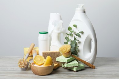 Photo of Eco-friendly cleaning products, supplies and eucalyptus branches on wooden table