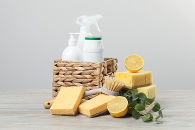 Photo of Eco-friendly cleaning products, supplies and eucalyptus branches on wooden table