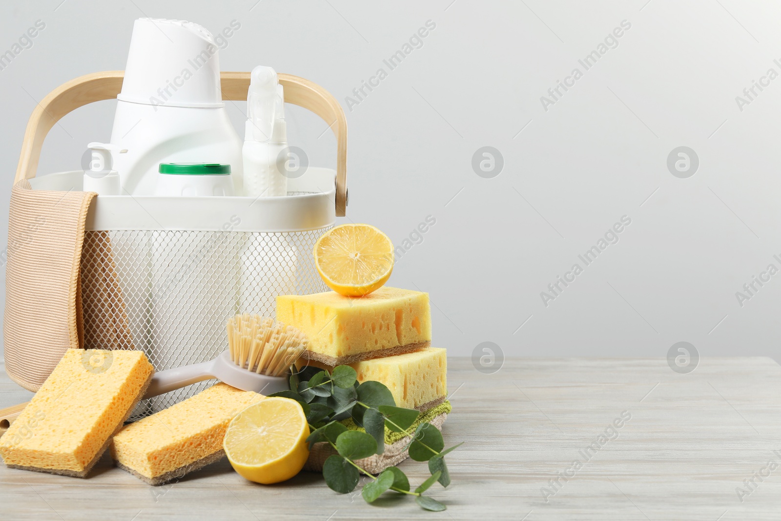 Photo of Eco-friendly cleaning products, supplies and eucalyptus branches on wooden table, space for text