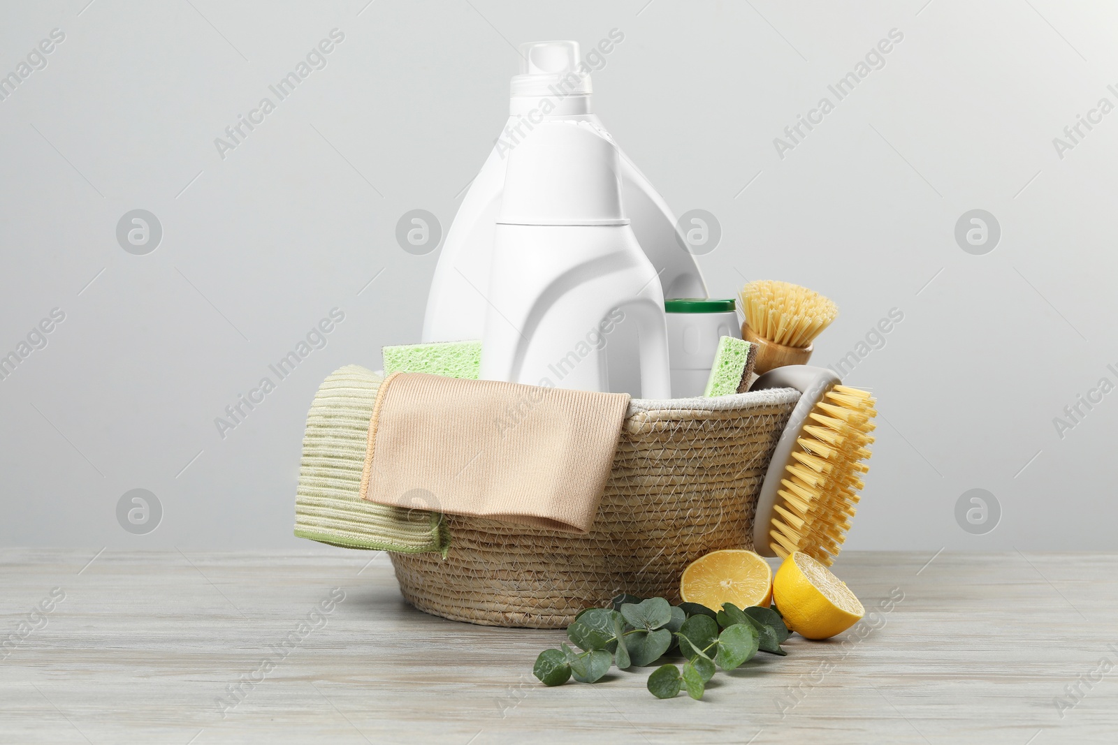 Photo of Eco-friendly cleaning products, supplies and eucalyptus branches on wooden table