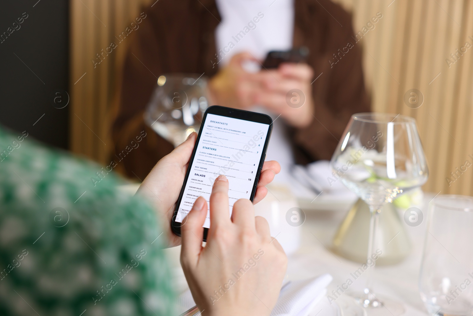 Photo of Couple choosing dishes from digital menu at restaurant, closeup