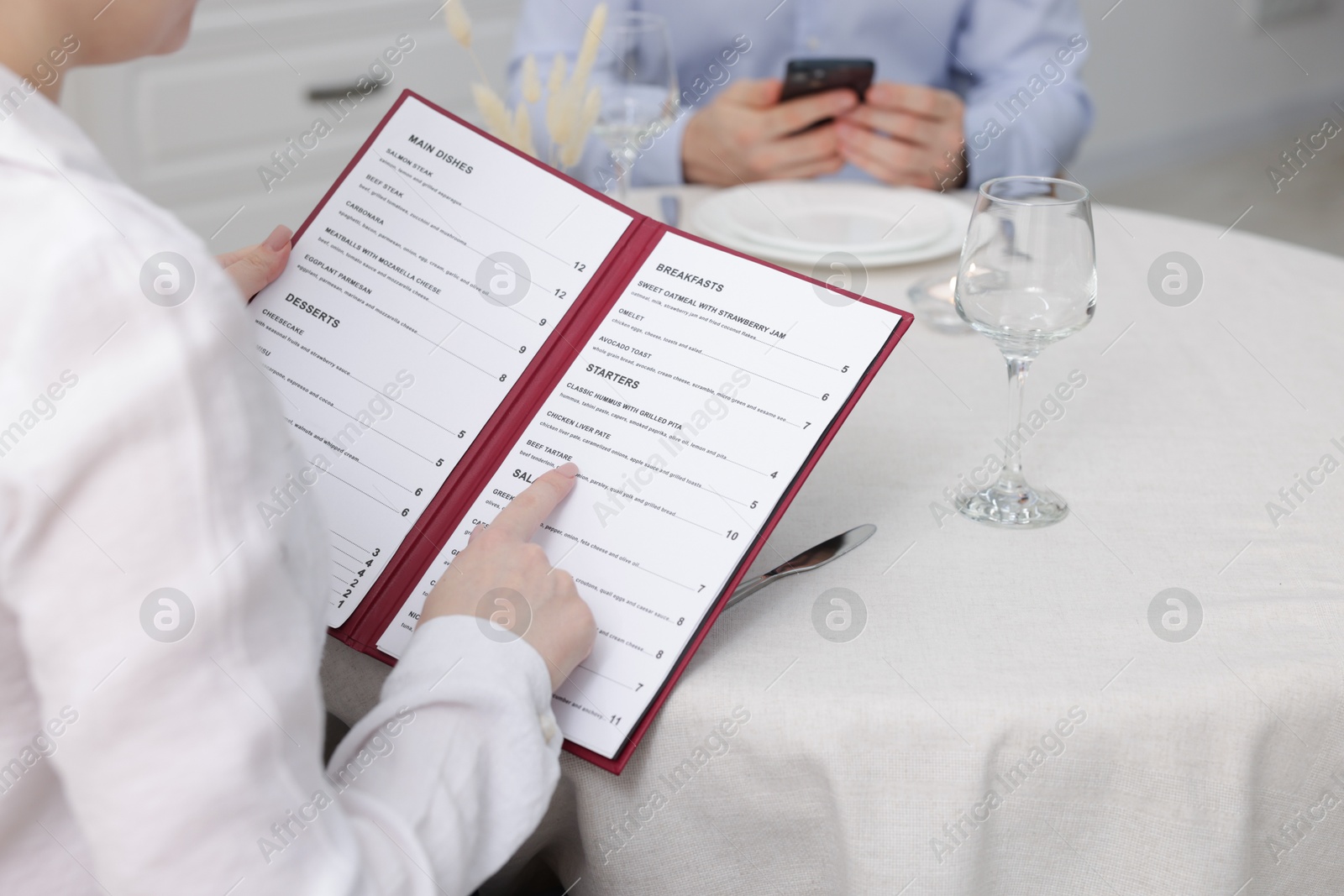 Photo of Woman with menu at table in restaurant, closeup