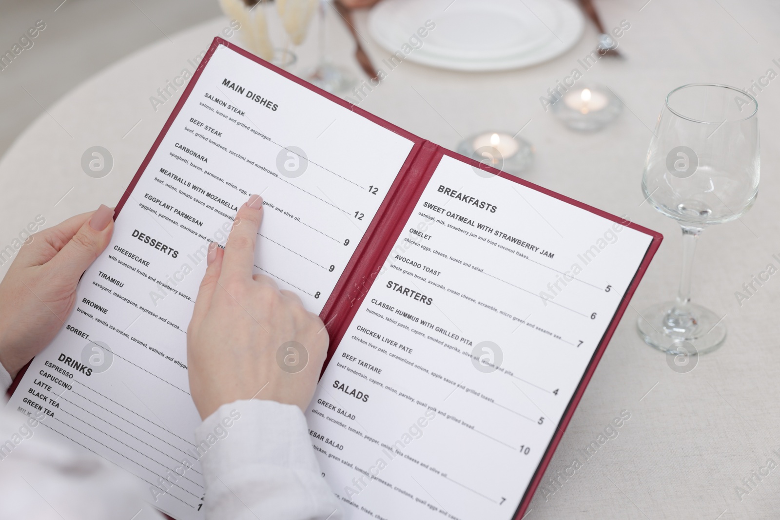 Photo of Woman with menu at table in restaurant, closeup