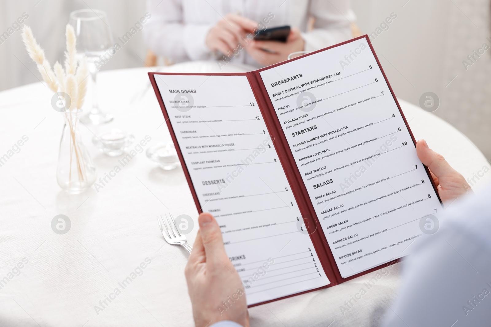 Photo of Man with menu at table in restaurant, closeup