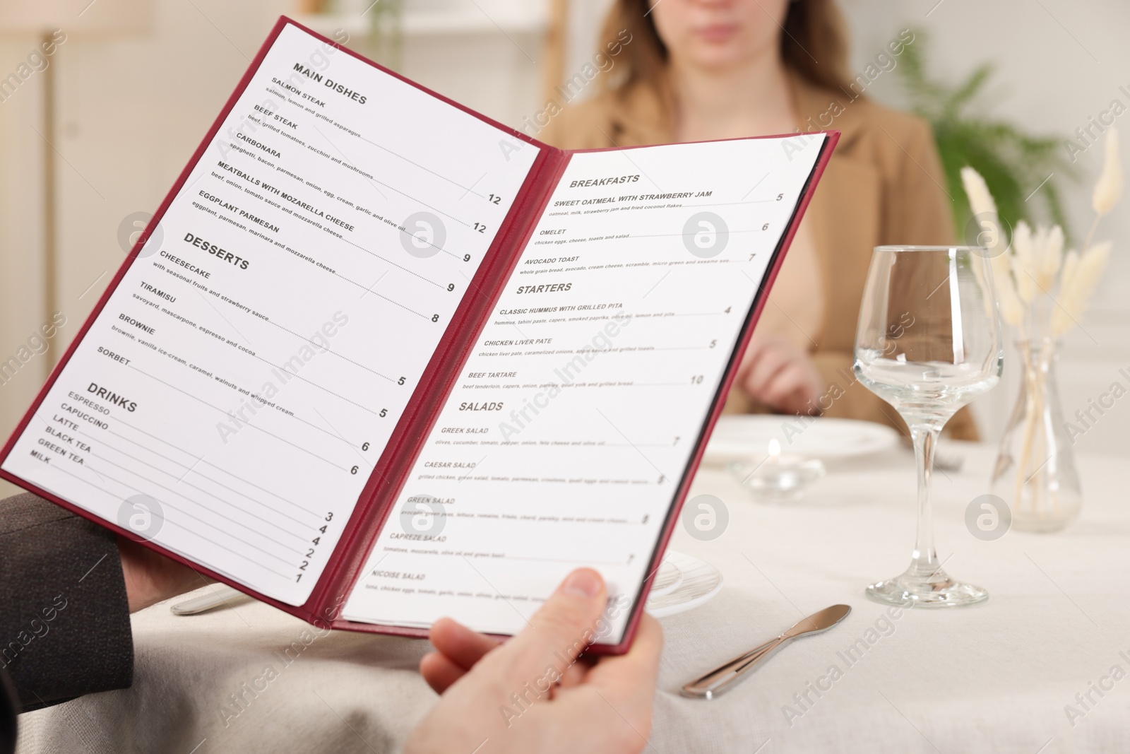 Photo of Man with menu at table in restaurant, closeup