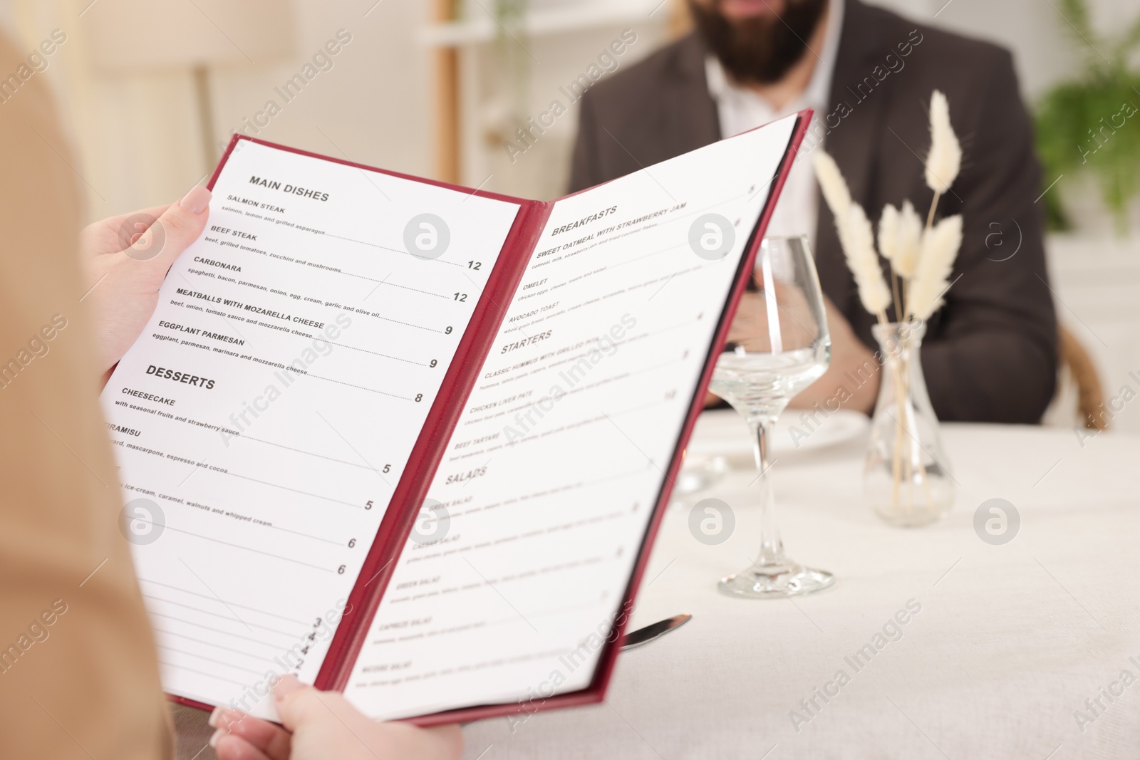 Photo of Woman with menu at table in restaurant, closeup