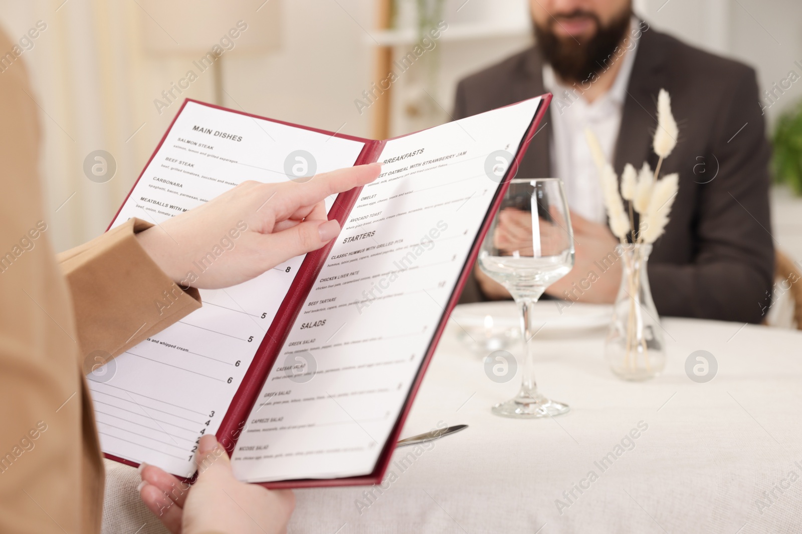 Photo of Woman with menu at table in restaurant, closeup