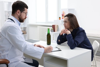 Photo of Alcoholic woman having appointment with healthcare specialist in clinic. Addiction treatment