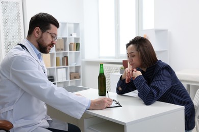 Photo of Alcoholic woman having appointment with healthcare specialist in clinic. Addiction treatment