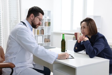 Photo of Alcoholic woman having appointment with healthcare specialist in clinic. Addiction treatment