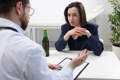 Photo of Alcoholic woman having appointment with healthcare specialist in clinic. Addiction treatment