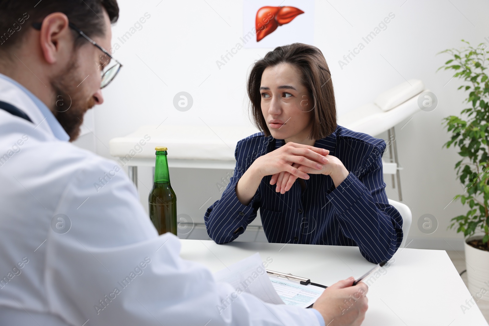 Photo of Alcoholic woman having appointment with healthcare specialist in clinic. Addiction treatment