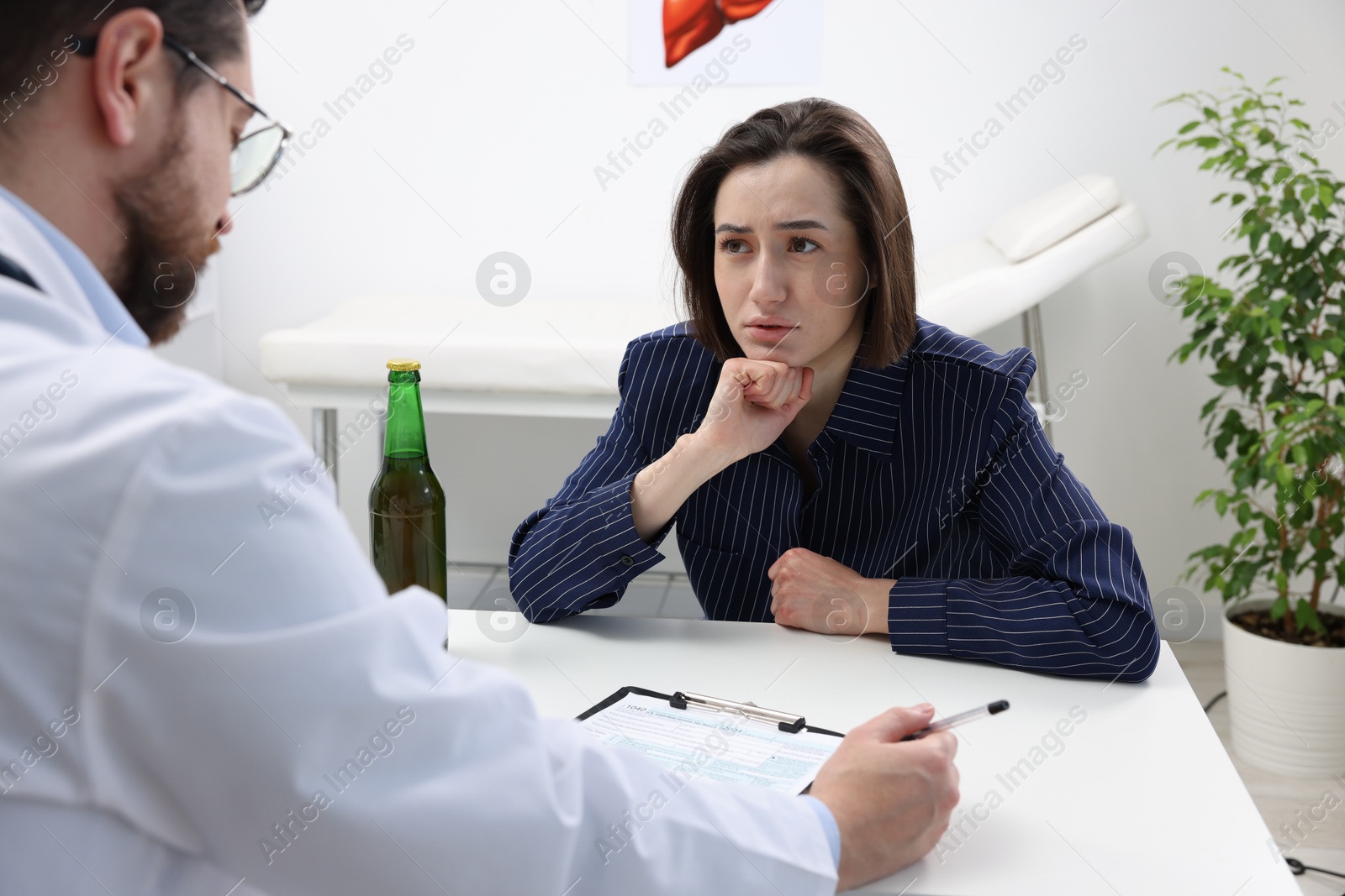 Photo of Alcoholic woman having appointment with healthcare specialist in clinic. Addiction treatment