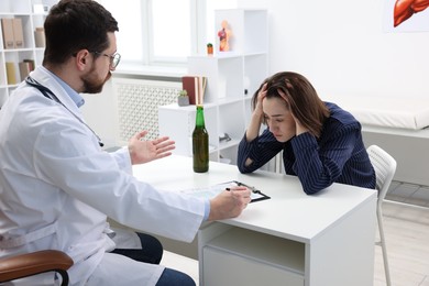 Photo of Alcoholic woman having appointment with healthcare specialist in clinic. Addiction treatment