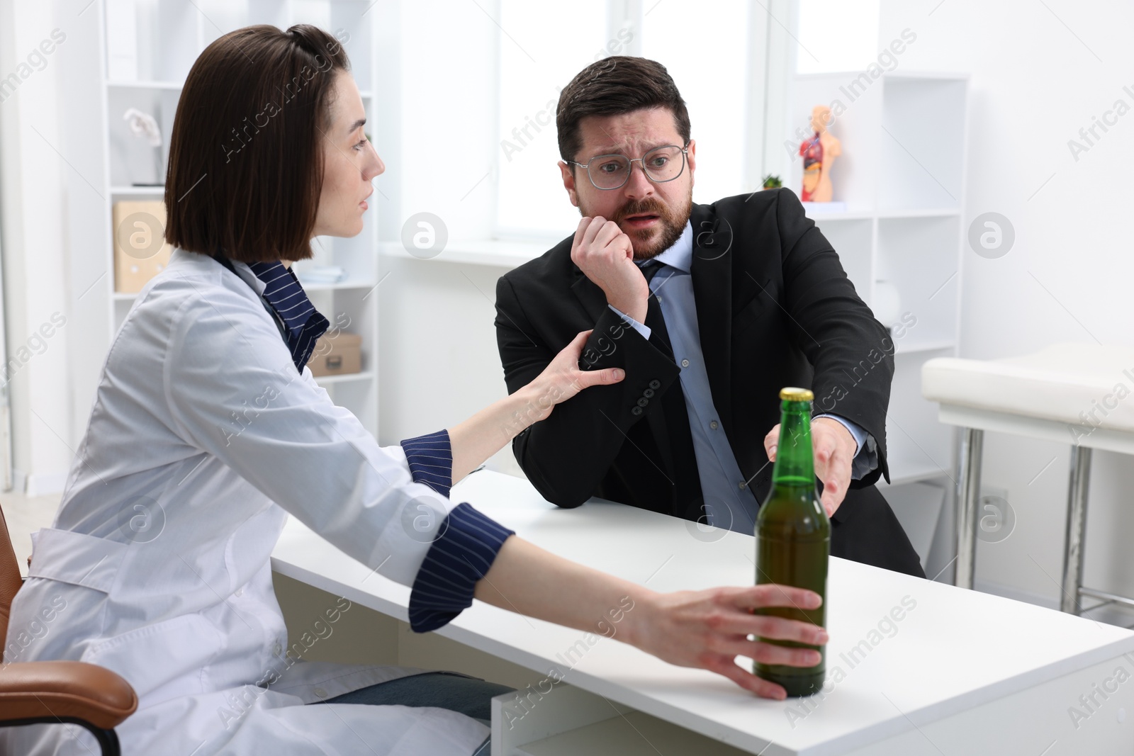 Photo of Alcoholic man having appointment with healthcare specialist in clinic. Addiction treatment