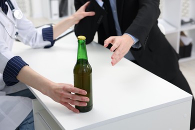 Photo of Alcoholic man having appointment with healthcare specialist in clinic, closeup. Addiction treatment