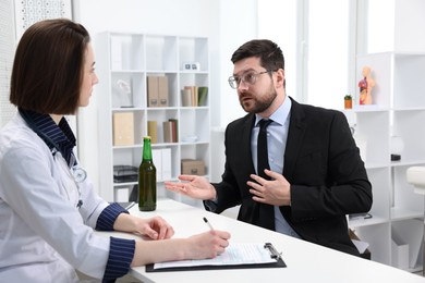 Photo of Alcoholic man having appointment with healthcare specialist in clinic. Addiction treatment