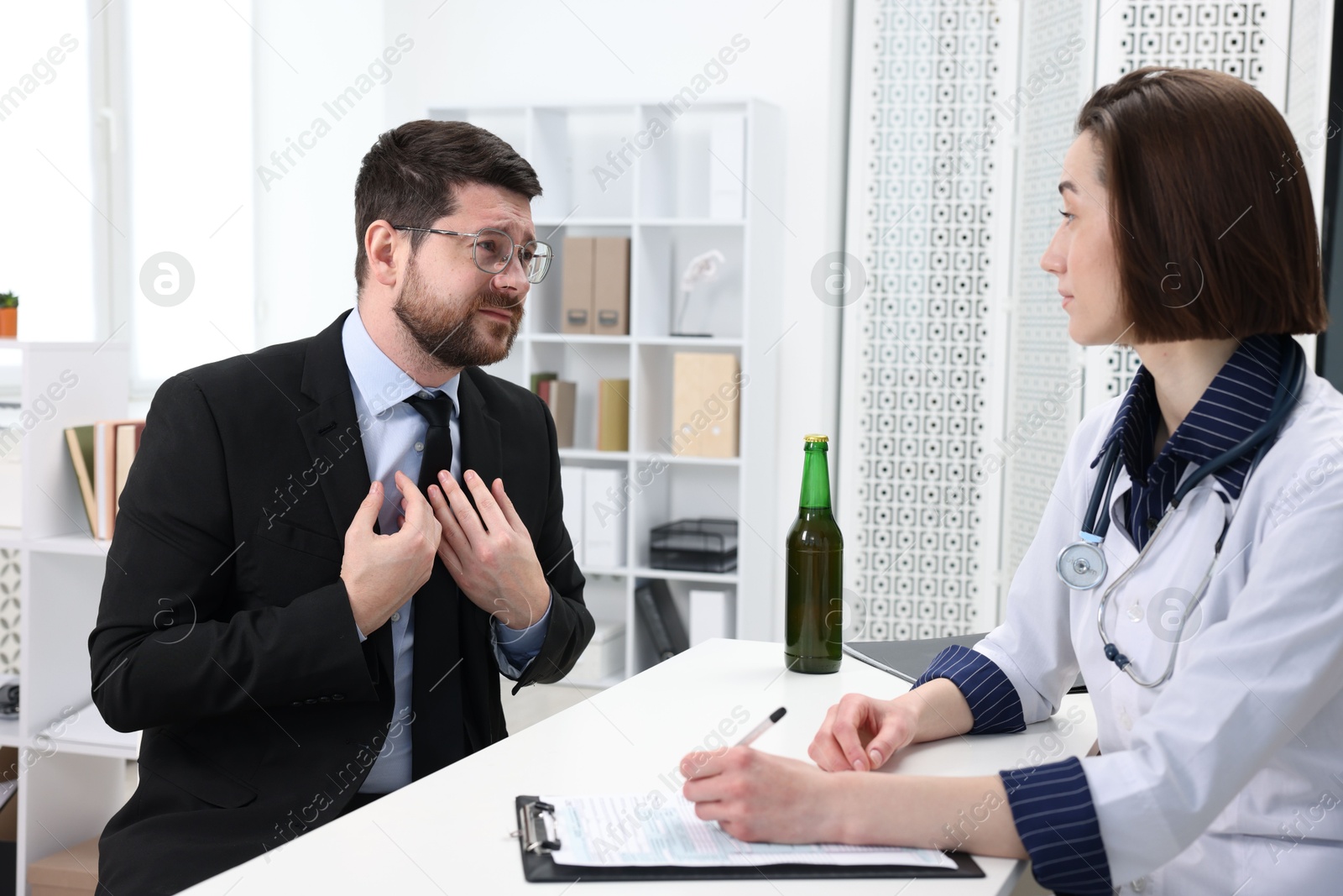 Photo of Alcoholic man having appointment with healthcare specialist in clinic. Addiction treatment