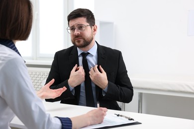 Photo of Alcoholic man having appointment with healthcare specialist in clinic. Addiction treatment